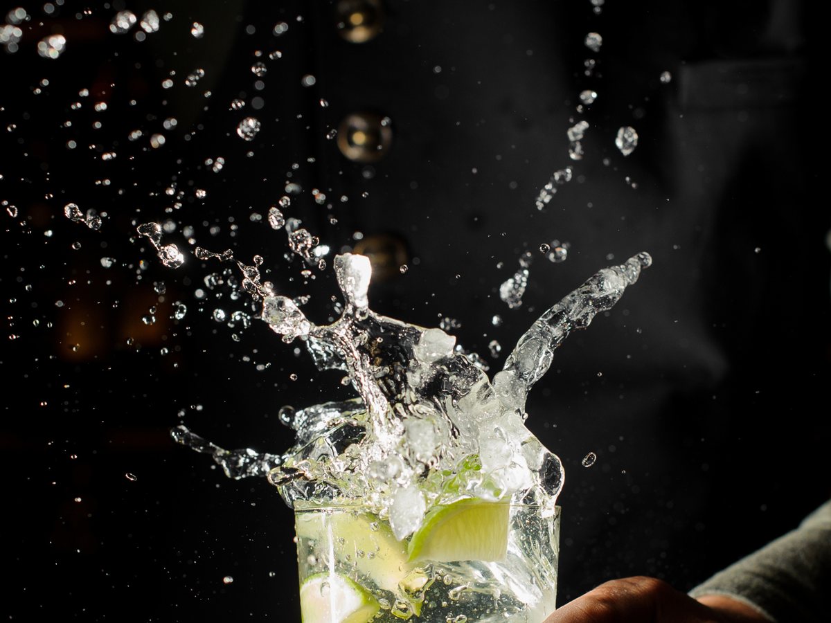 Ghiaccio e lime in movimento sopra il bicchiere
