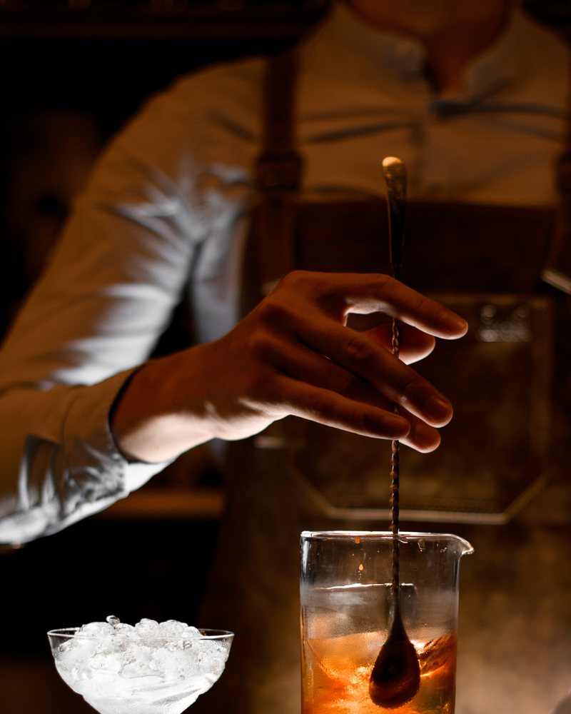 Barman che miscela al banco durante un servizio